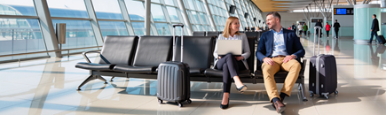 Zwei Geschäftsreisende sitzen am Flughafen am Abfluggate